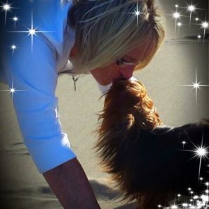 woman kissing yorkie dog