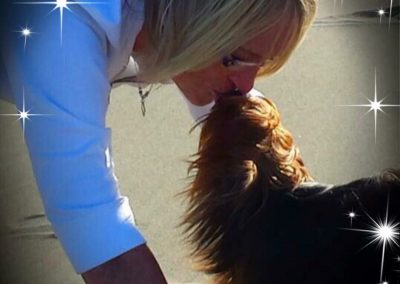 woman kissing yorkie dog